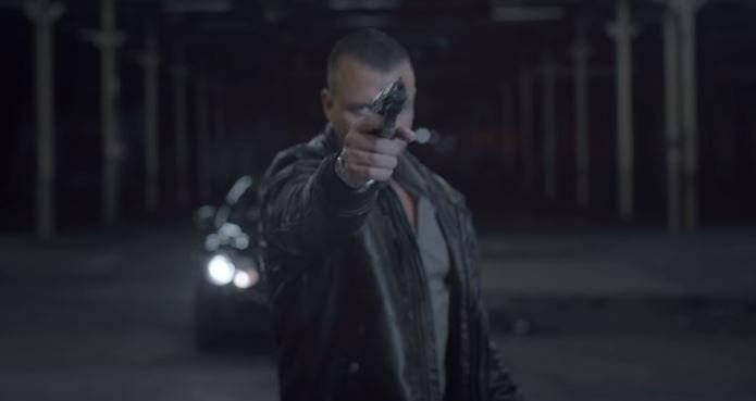 Kollegah mit erhobener Pistole im Musikvideo