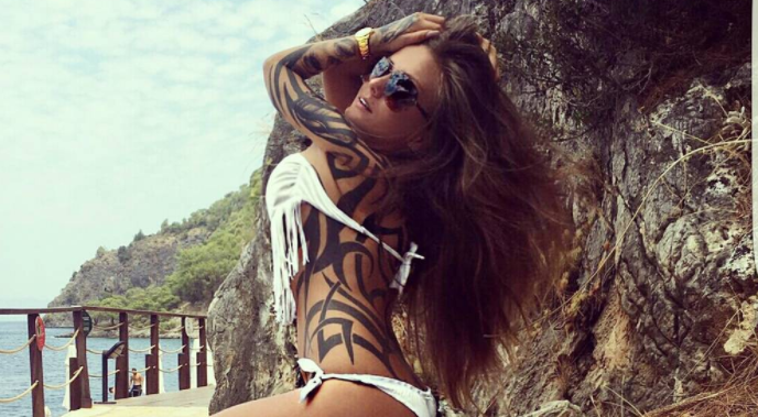 Schwesta Ewa in weißem Bikini mit Tattoos am Berg